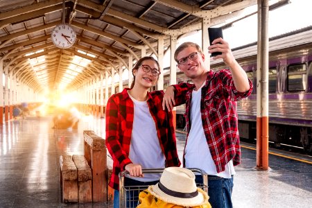 Man And Woman At The Train Station Taking A Selfie photo