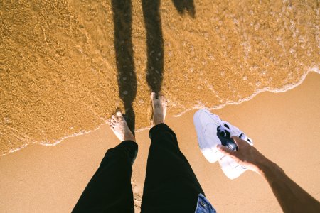 Photo Of Person Holding Sneakers