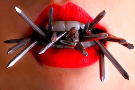 Woman Biting Gray Nails In Her Mouth