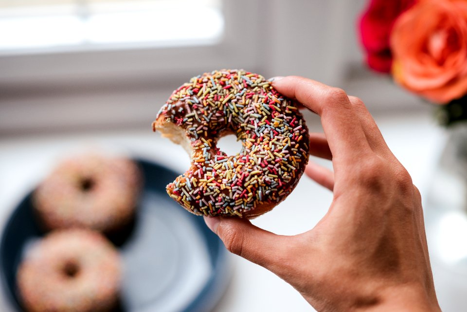 Person Holding Doughnut With Sprinkles