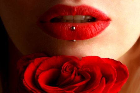 Woman Wearing Red Lipstick Near Red Rose photo