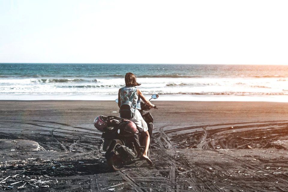 Woman Riding Motor Scooter On Seashore