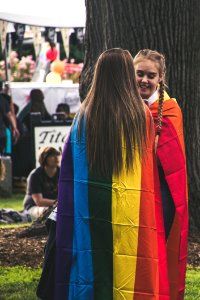 Photo Of Two Woman Wearing Rainbow Capes photo