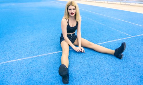 Woman Wearing Black Sports Bra And Black Shorts Sitting On Ground