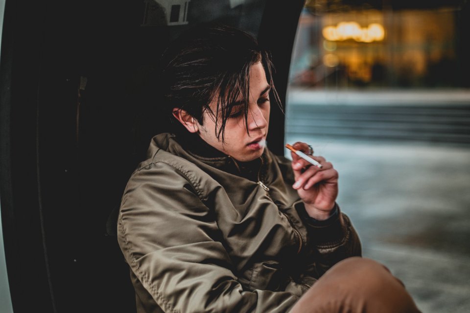 Man Wearing Gray Jacket Holding Cigarette