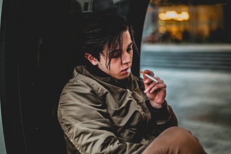 Man Wearing Gray Jacket Holding Cigarette photo
