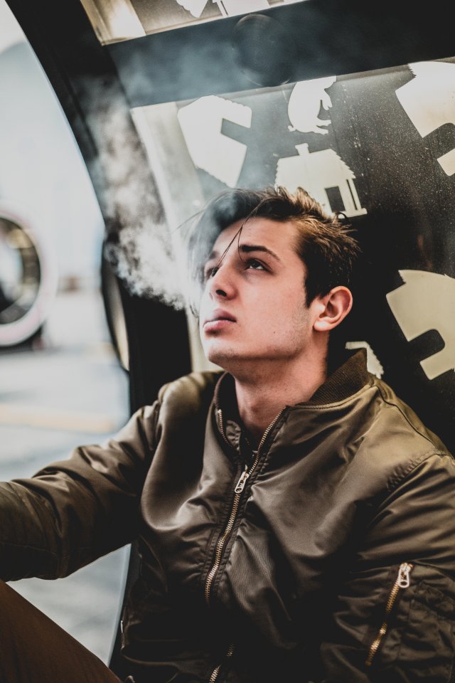 Man Wearing Brown Leather Zip-up Jacket Using Cigarette