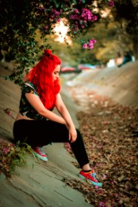 Woman Wearing Multicolored Cap-sleeved Crop Top And Black Pants On Concrete Pavement Under Purple Bougainvillea Flowers photo