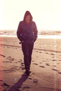 Man Walking On Beach Wearing Black Leather Coat