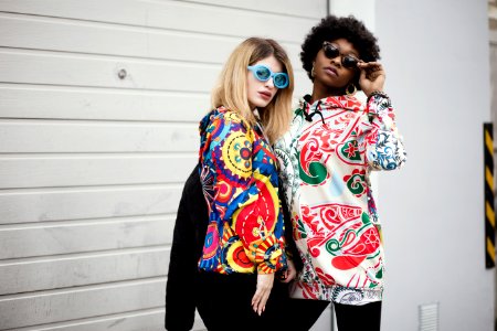 Two Women Standing Near Roller Shutter photo