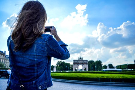 Woman Wearing Blue Denim Jacket Standing While Holding Smartphone photo