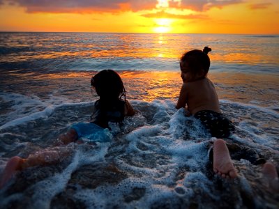 Photo Of Two Girls In Beach During Golden Hour photo