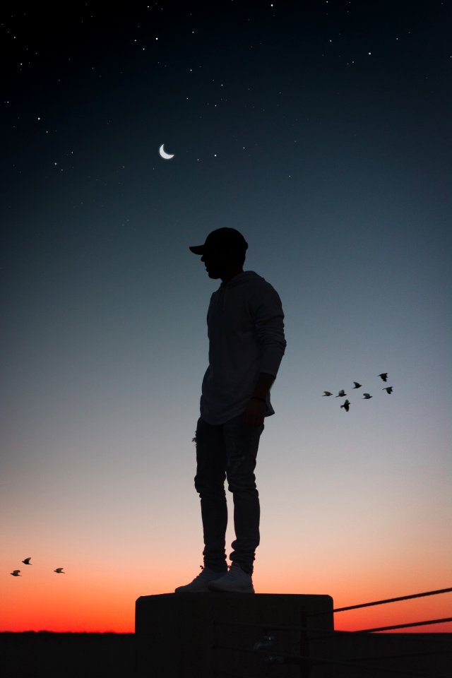 Silhouette Photo Of Man Standing On Concrete Surface photo