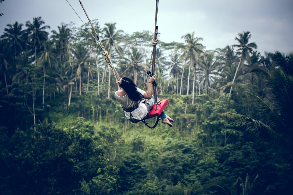 Black Haired Woman Riding A Swing