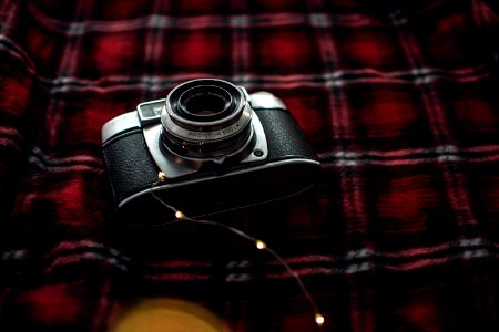 Black And Gray Point-and-shoot Camera On Red Black And White Plaid Textile