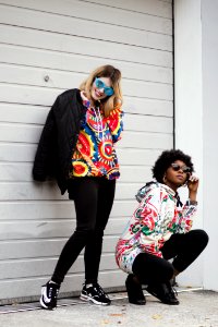 Women Wearing Multicolored Pullover Hoodie And Black Jacket