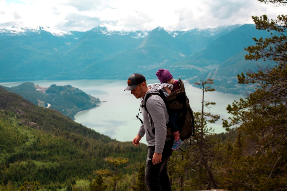Man Carrying Baby Near Lake