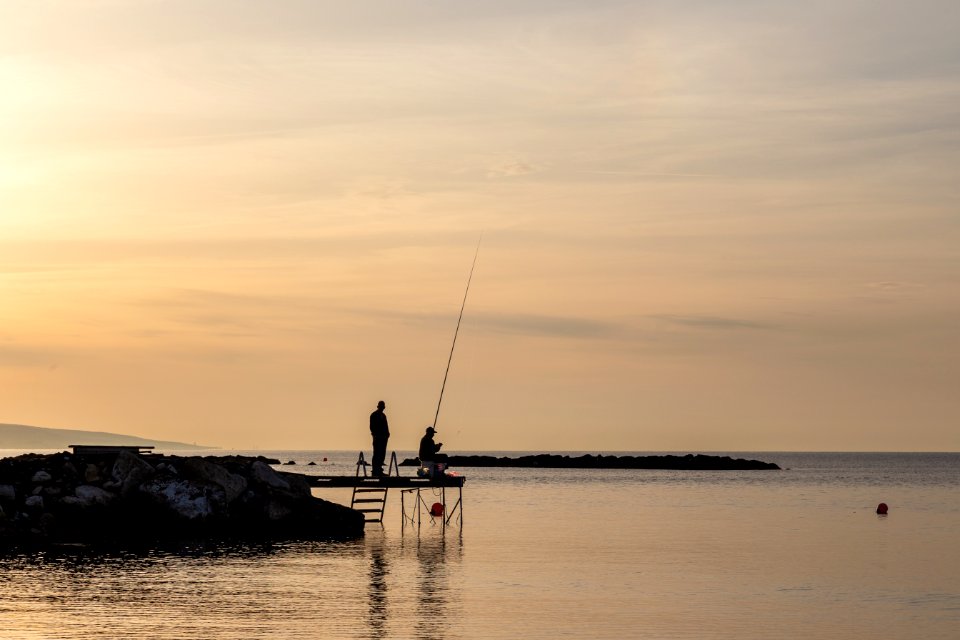 Two Person Having Fishing On Dock