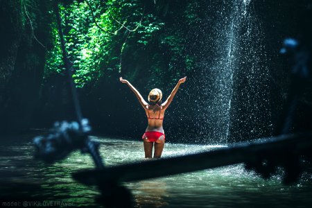 Young Woman Tourist With Straw Hat Deep In The Rainforest With Waterfall Background Bali Island photo