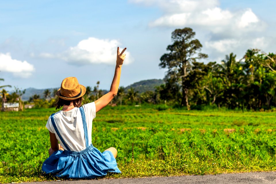 Tropical Portrait Of Young Happy Woman With Straw Hat On A Road With Coconut Palms And Tropical Trees Bali Island