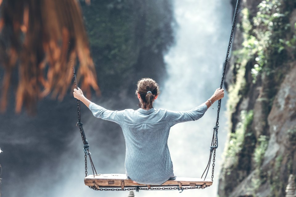 Beautiful Woman Swings Near Waterfall In The Jungle Of Bali Island, Indonesia