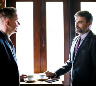 Two Person Talking In Front Of Brown Wooden Table With Cup Of Coffees photo