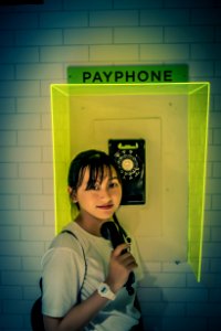 Photo Of Woman Standing Beside Payphone photo
