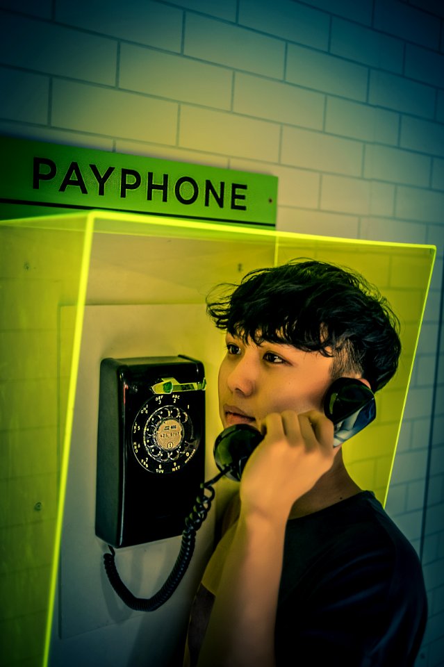 Man Holding Black Rotary Payphone