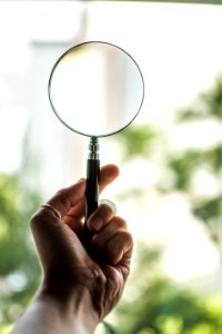 Tilt Shift Lens Photography Of Person Holding Magnifying Glass photo