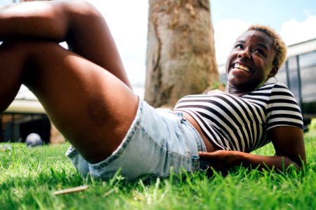 Woman Wearing Black And White Striped Shirt Lying On Green Grass At Daytime photo