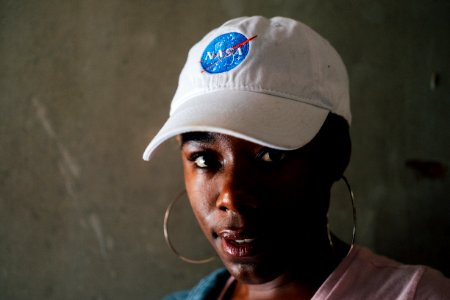 Woman Wearing Hoop Earrings And Nasa Baseball Cap