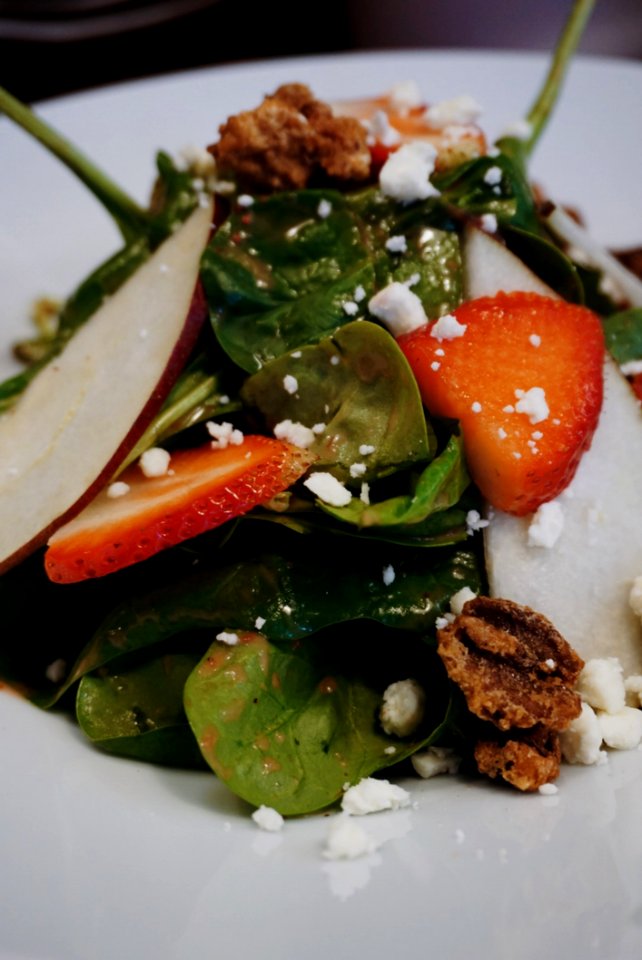 Sliced Strawberry And Green Leaf Vegetables On White Ceramic Plate