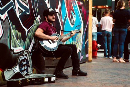 Man Playing Black Cutaway Guitar photo