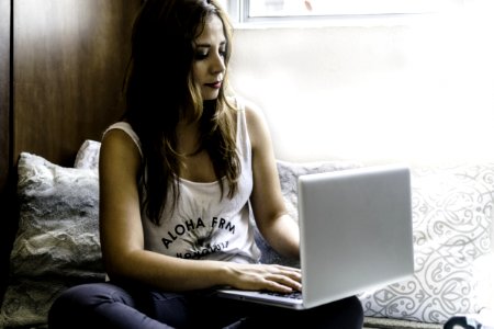 Woman Sitting On Couch With Macbook Pro On Lap photo