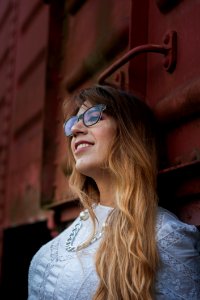 Woman In White Top Wearing Silver-colored Chain Necklace Leaning On Train photo