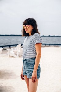Smiling Woman Wearing Black And White Striped Shirt And Blue Short Shorts photo