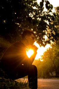 Man Sitting On Grass Near Tree