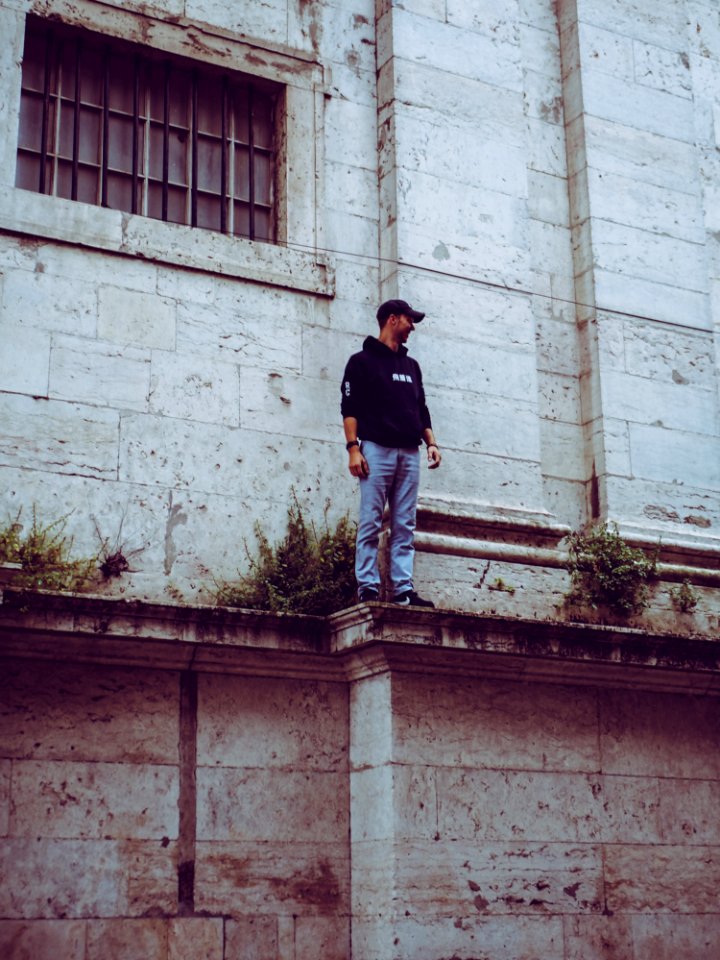Man In Black Hooded Jacket Standing On Edge