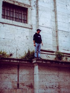 Man In Black Hooded Jacket Standing On Edge photo