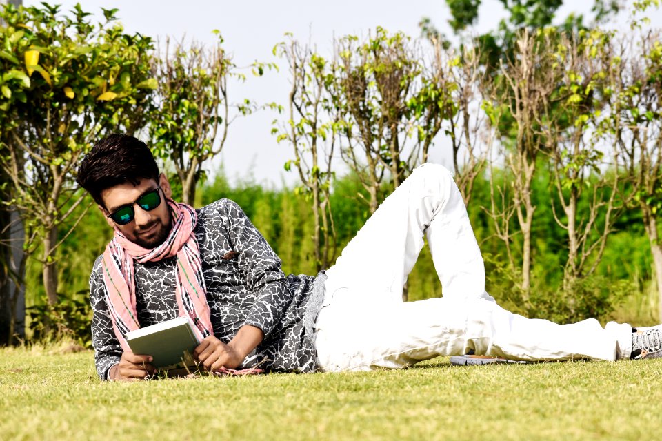 Man In White Pants Wearing Sunglasses Reading Book