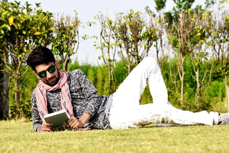 Man In White Pants Wearing Sunglasses Reading Book