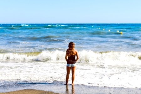 Photo Of Woman Standing On Seashore photo