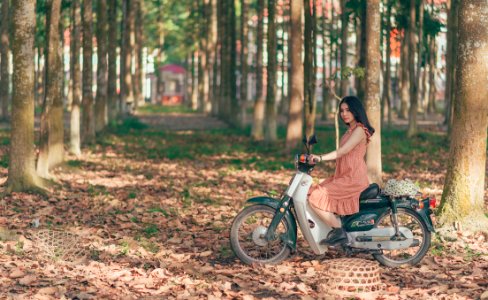 Woman Riding Underbone Motorcycle Between Trees