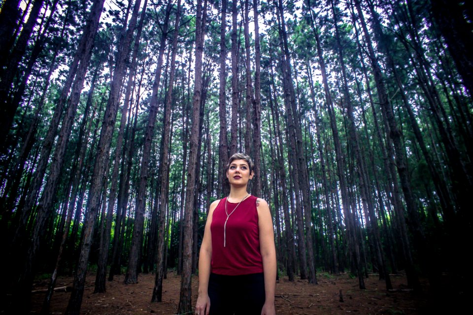 Woman Wearing Maroon Tank Top And Black Bottoms Surrounded With Brown Trees