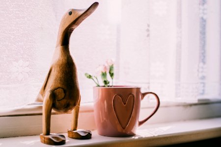 Brown Wooden Duck Figurine Near Brown Ceramic Mug photo