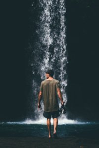 Man Wearing Gray Shirt Walking Near Waterfalls photo