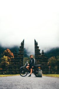 Photo Of Man Sitting On Motorcycle Near Tower photo