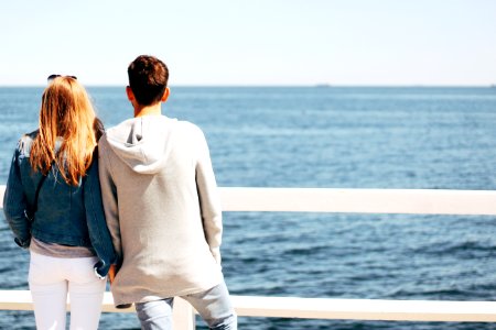 Man And Woman Beside Wooden Hand Rail Beside Body Of Water photo