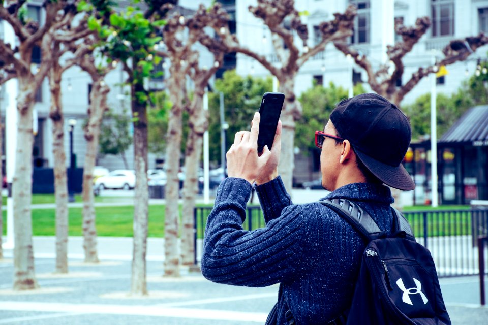 Man Wearing Black Jacket And Holding Black Android Smartphone