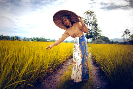Woman Wearing Brown Long-sleeved Top And White And Blue Skirt Near Green Plants photo